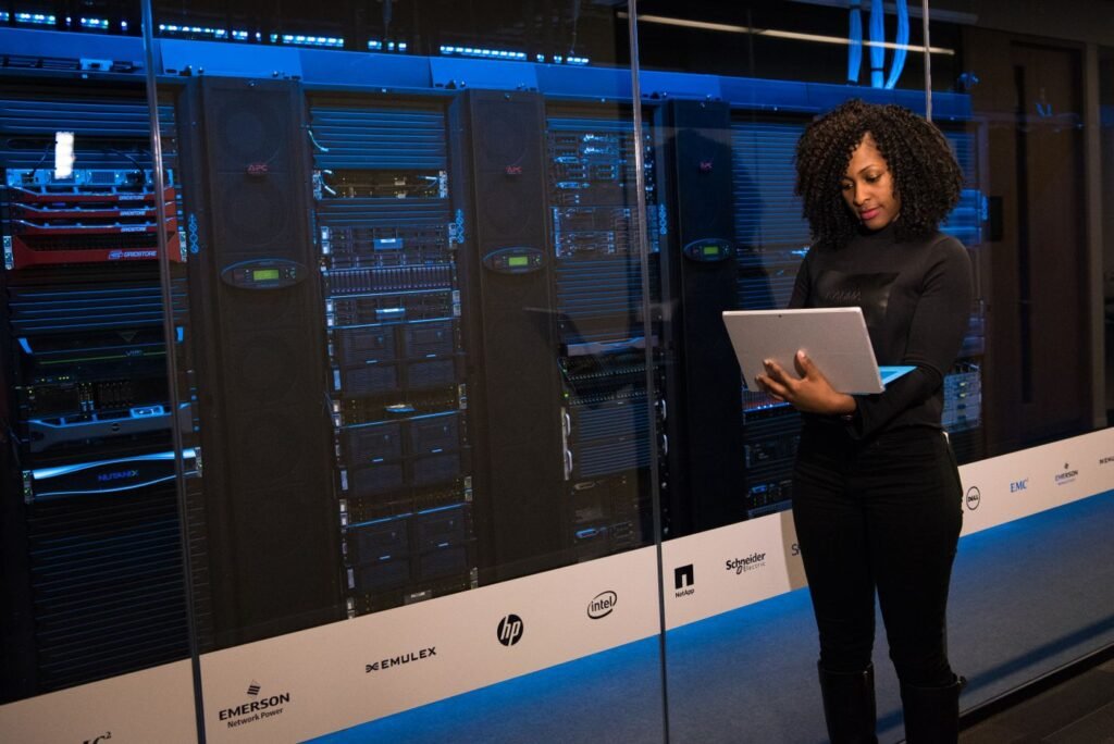 Engineer checking servers with a laptop beside server racks