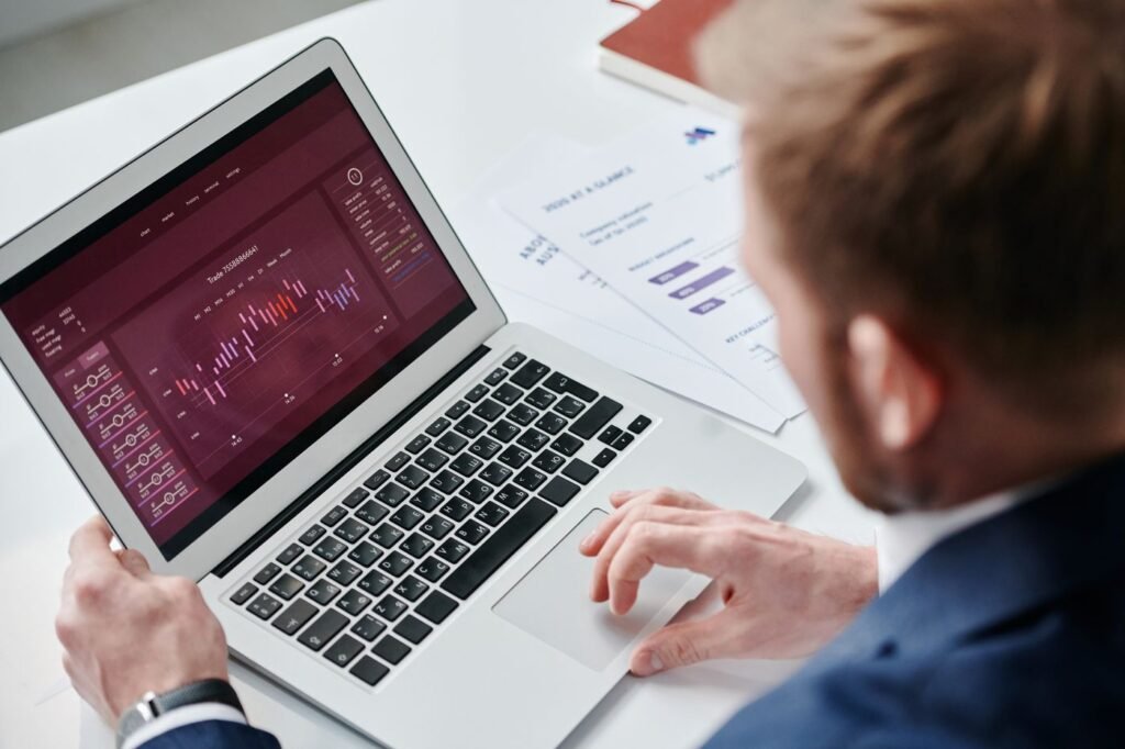 Businessman reviewing a data dashboard on a laptop in a bright office