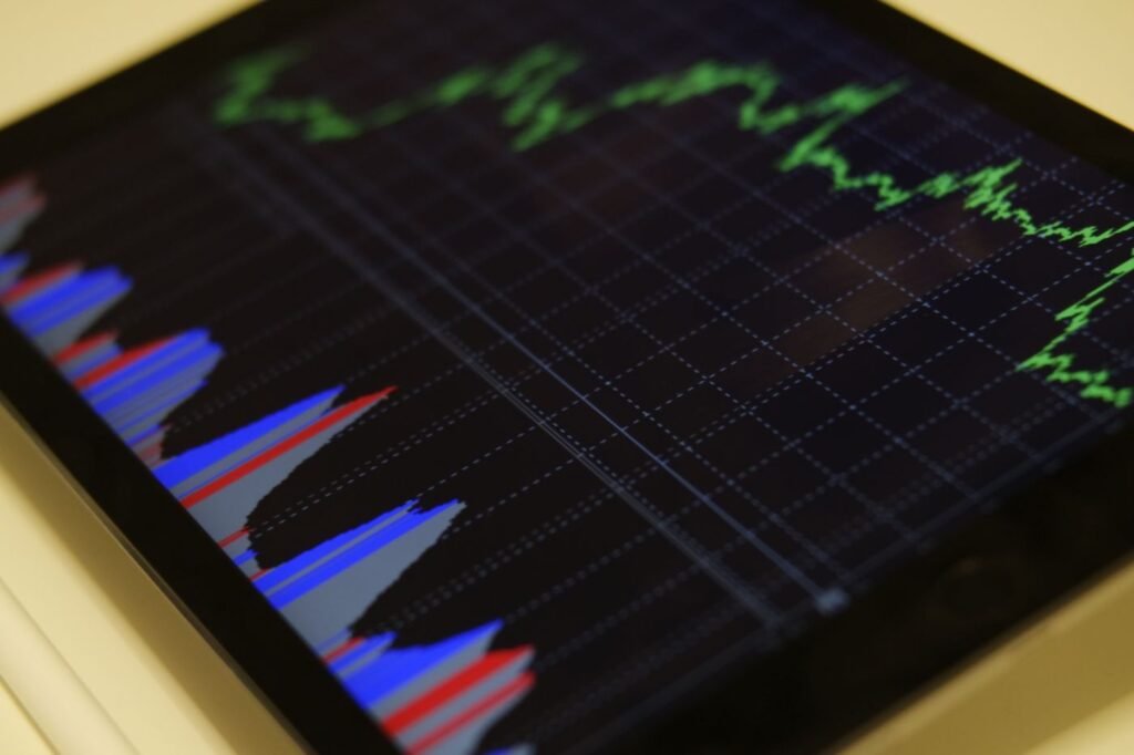Tablet screen showing colourful stock market charts and graphs