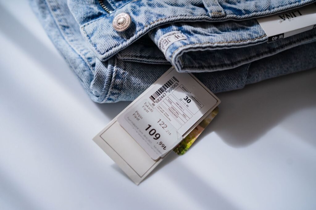 Blue jeans on a white table with a retail price and size label