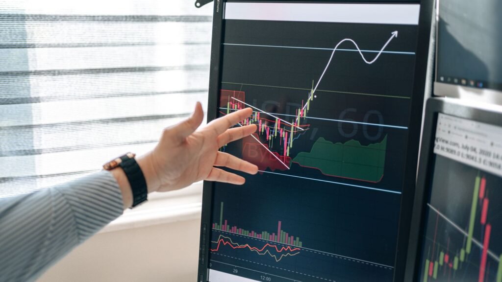 Person pointing at a graph on a computer monitor
