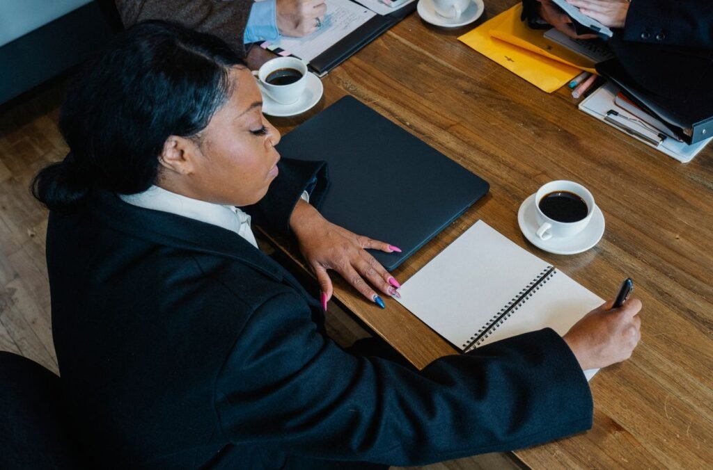 Overhead view of a businesswoman taking notes at a meeting