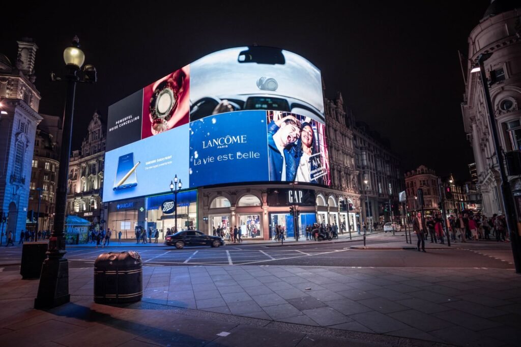 Illuminated billboards above a busy street at night