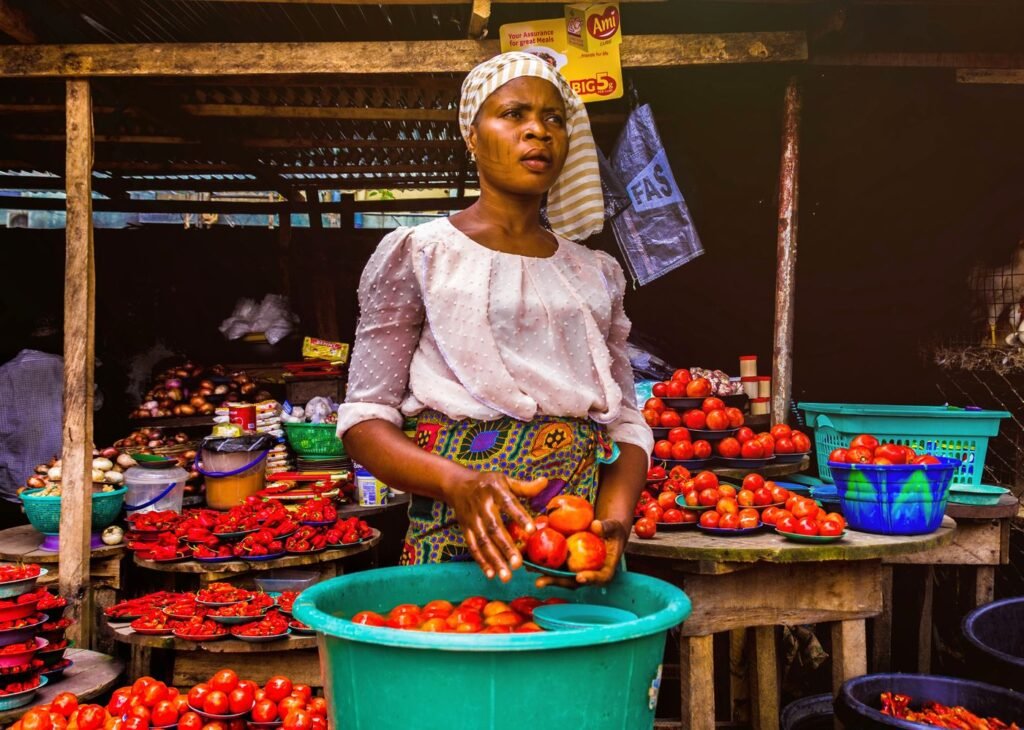 Woman selling fresh tomatoes at an outdoor market stall