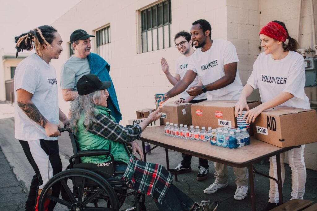 Volunteers handing out bottled water and supplies to people outdoors