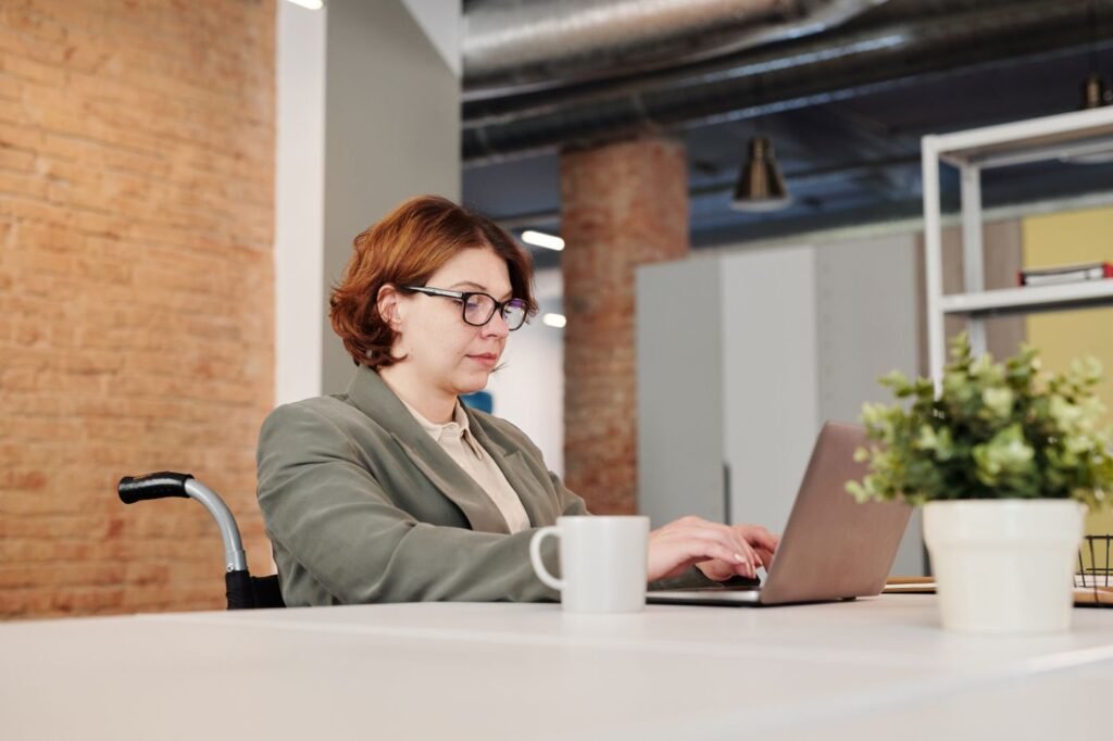A woman in a wheelchair working on a laptop