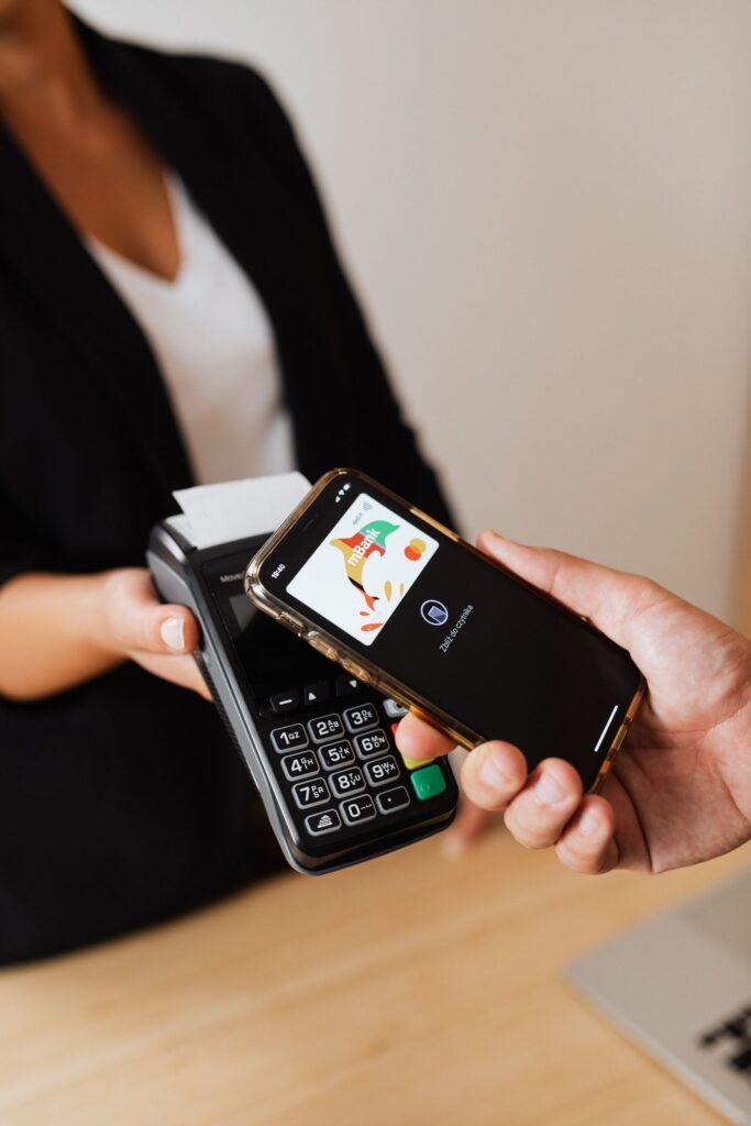 A person paying with a smartphone at a shop payment terminal