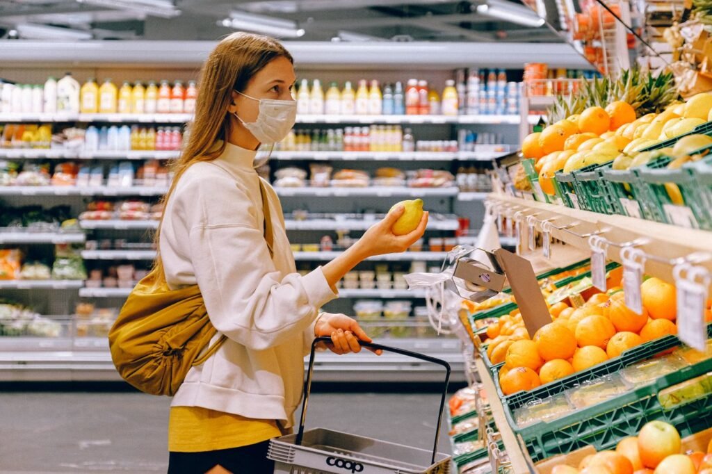 Shopper choosing fruit at a supermarket produce stand