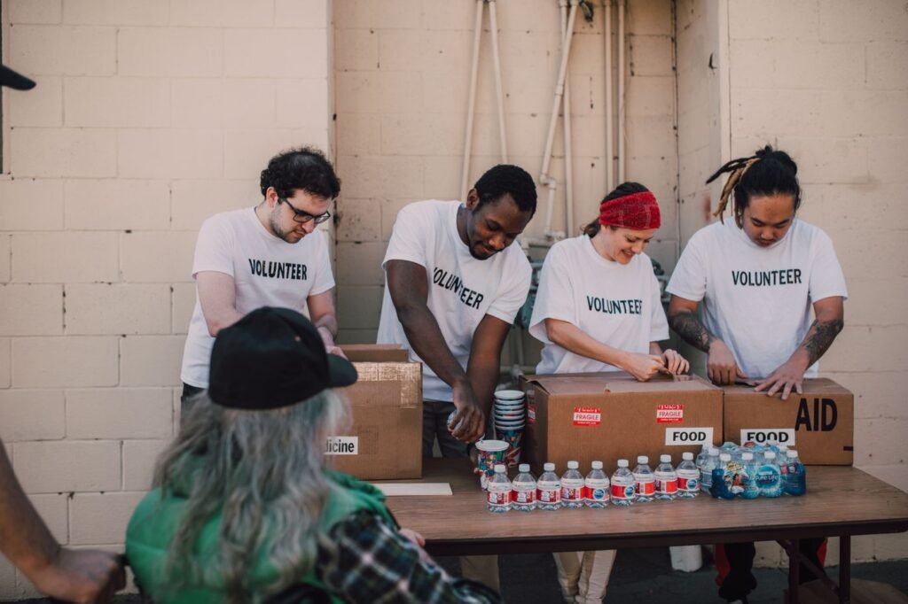 Volunteers opening and sorting boxes of donated food outdoors