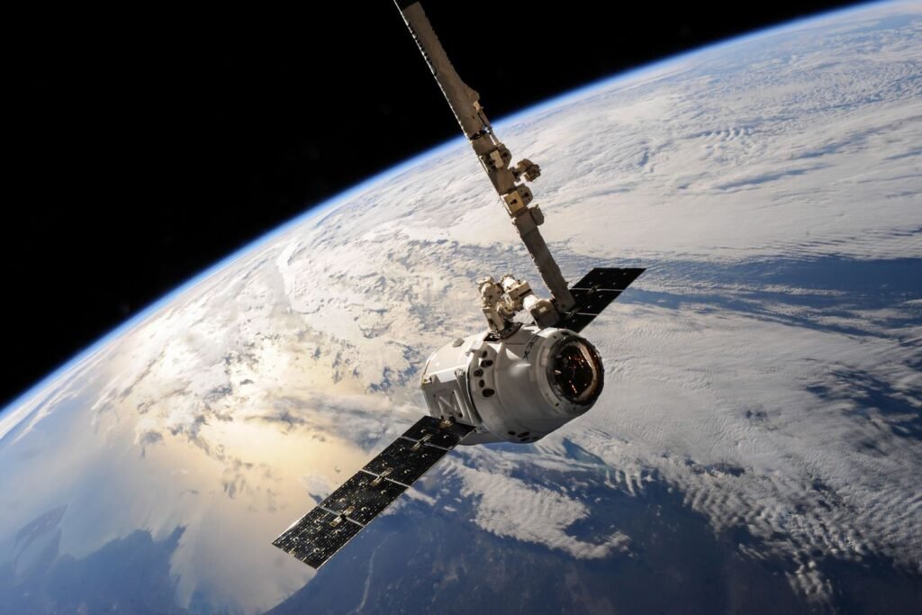 A satellite in orbit above Earth with clouds below