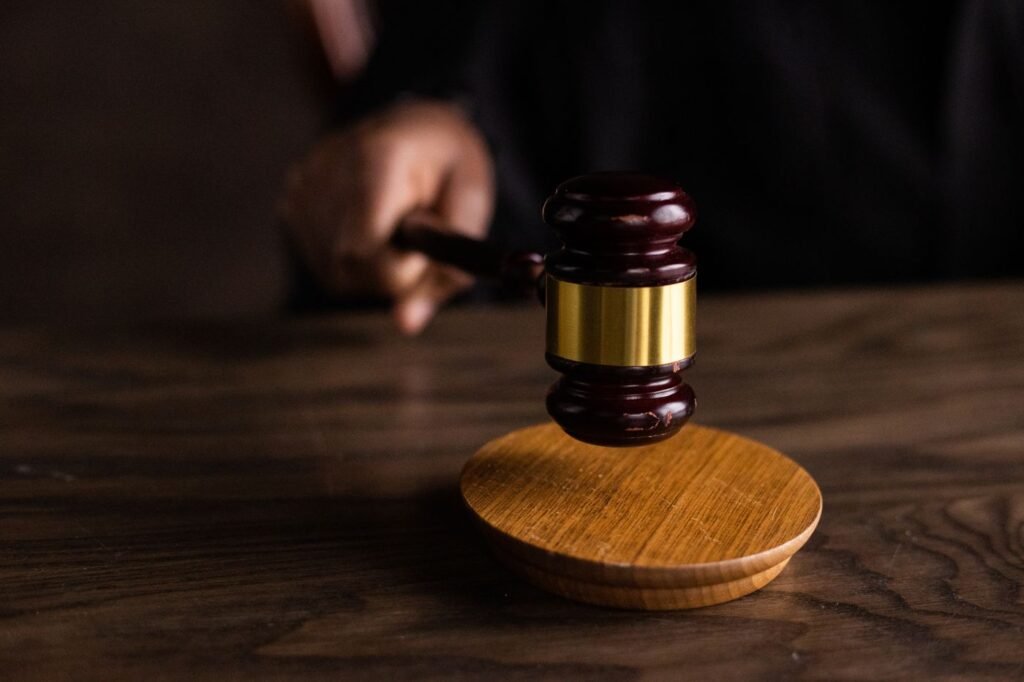 A wooden gavel striking a sound block on a wooden table