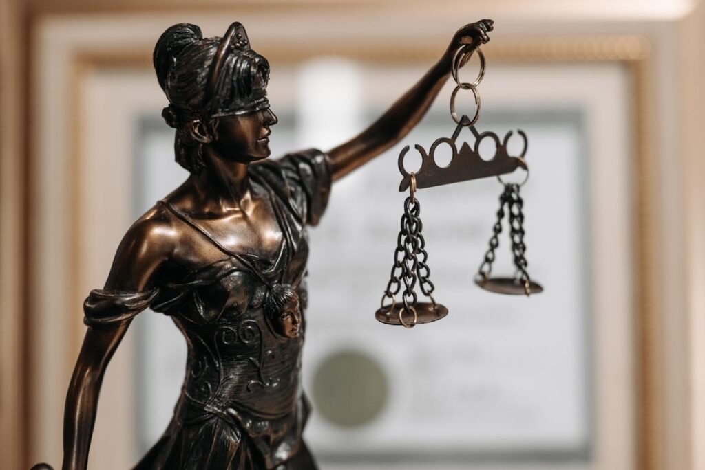 A bronze Lady Justice statue holding scales in an office