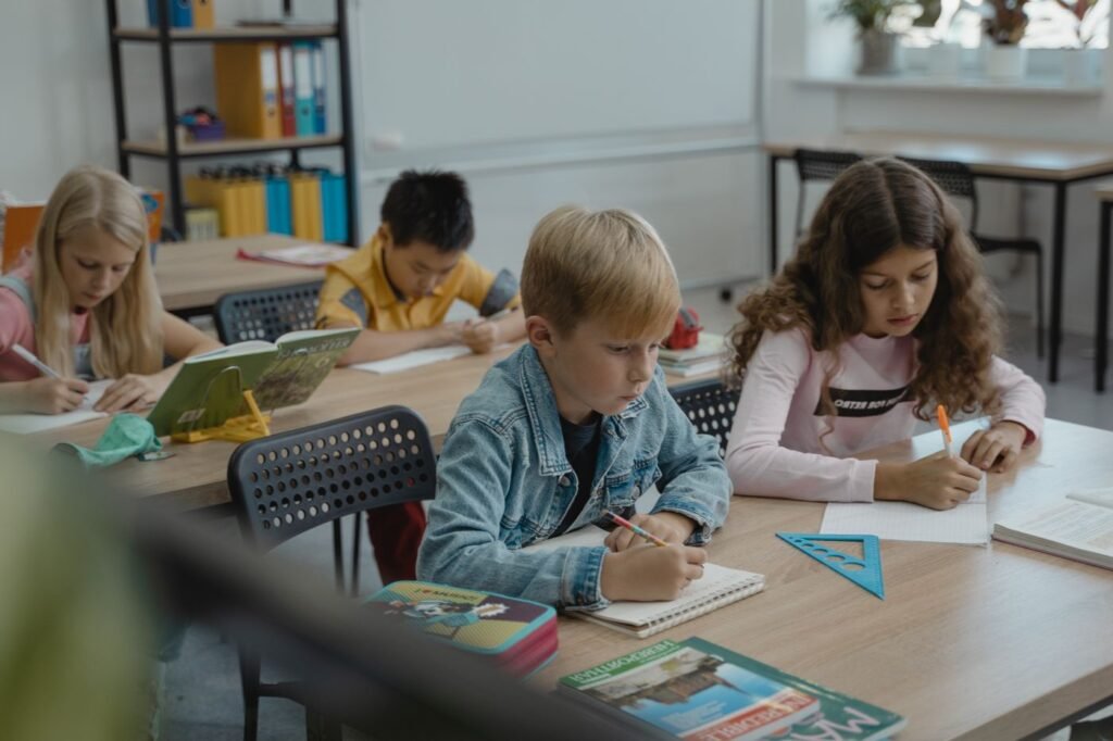 Children taking notes at desks in a classroom