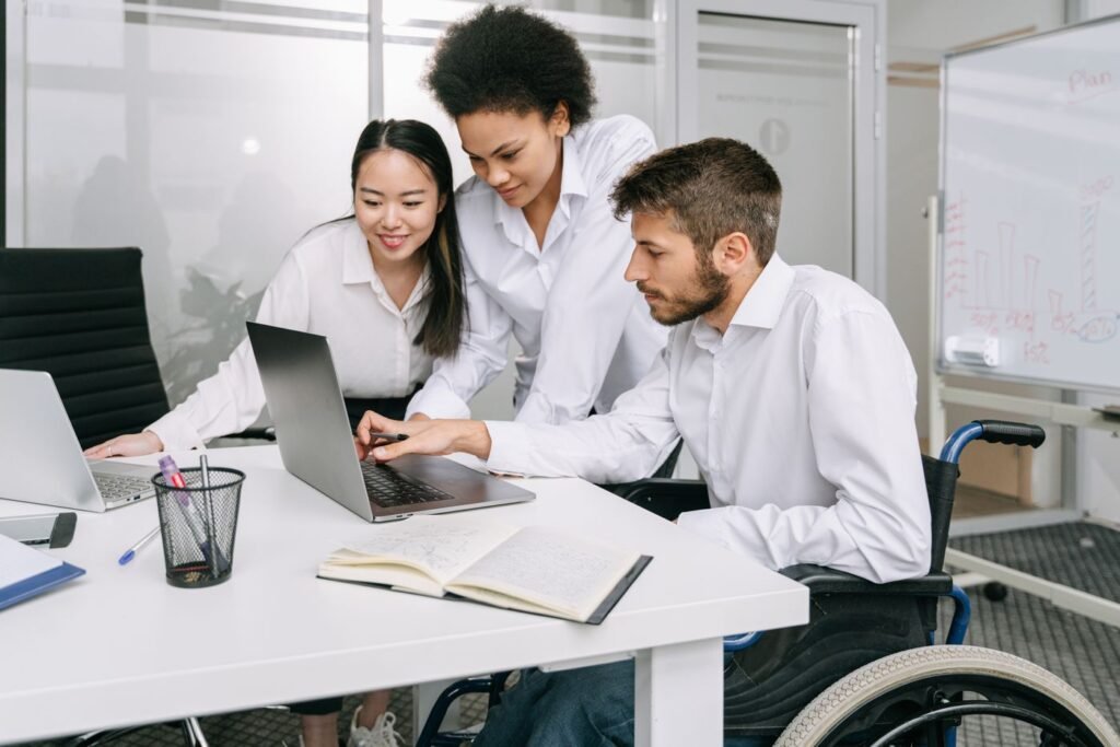Coworkers looking at a laptop together in a modern office