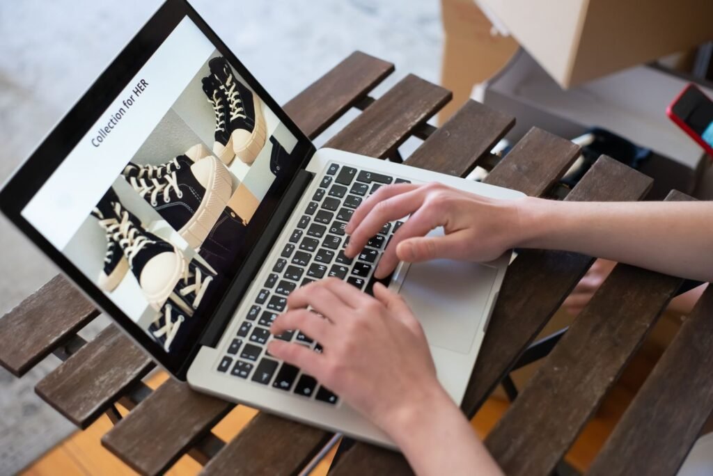 Close-up of a person using a laptop to build a fashion product collection