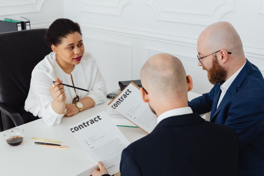 Three professionals reviewing a contract in a modern office